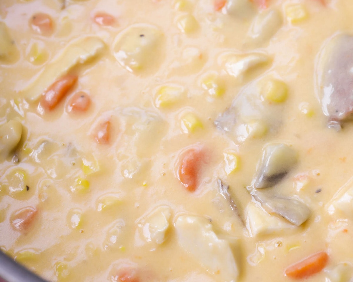 Close up of chicken and corn chowder cooking in a pot