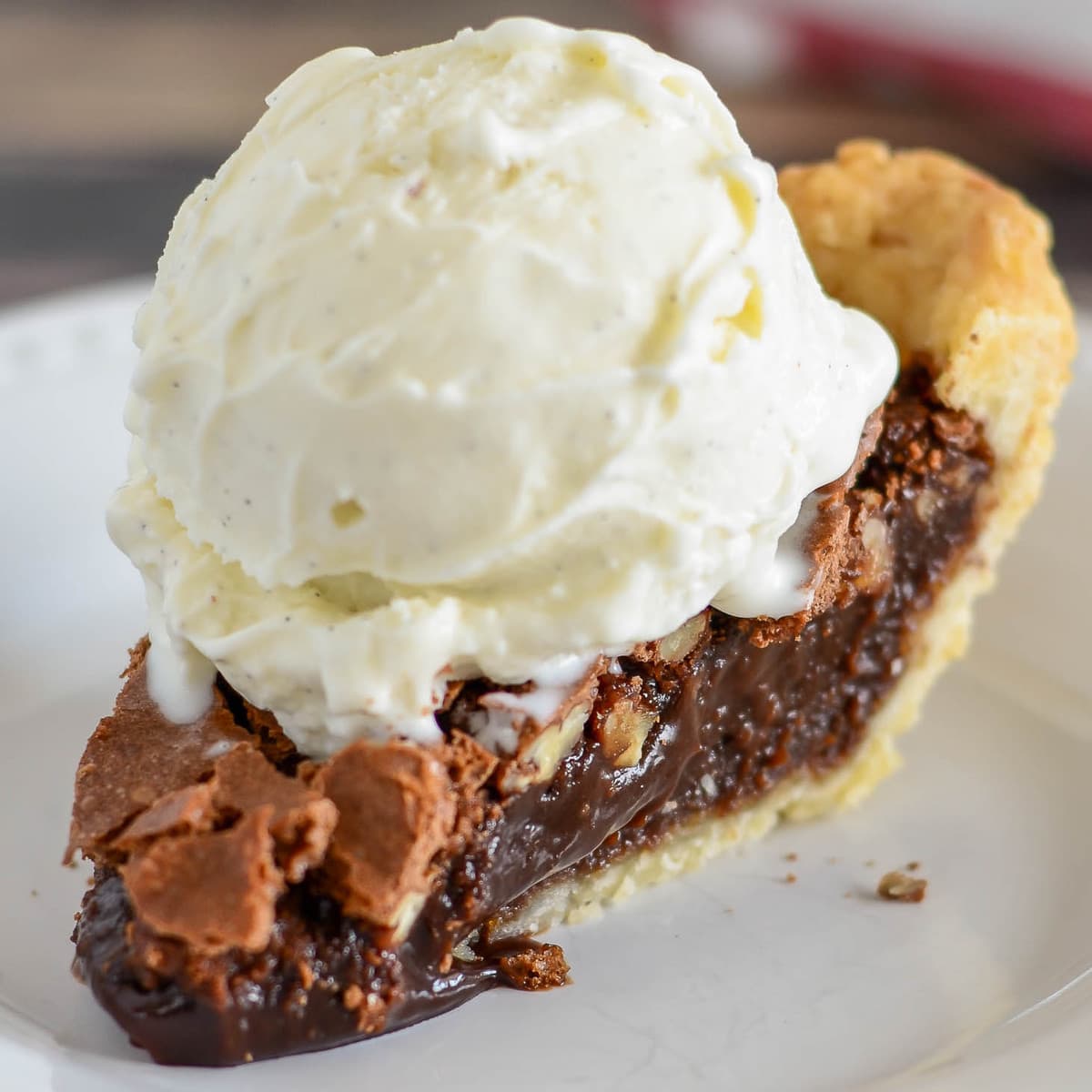 Thanksgiving desserts - a slice of chocolate pecan pie on a white plate.