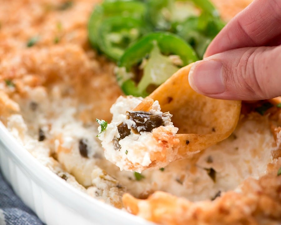 Christmas appetizers -  scooping jalapeno popper dip onto a chip.