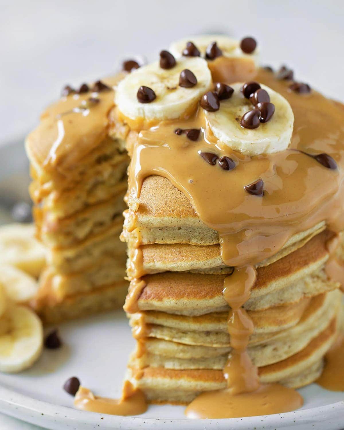 Peanut Butter Pancakes topped with peanut butter syrup and banana slices