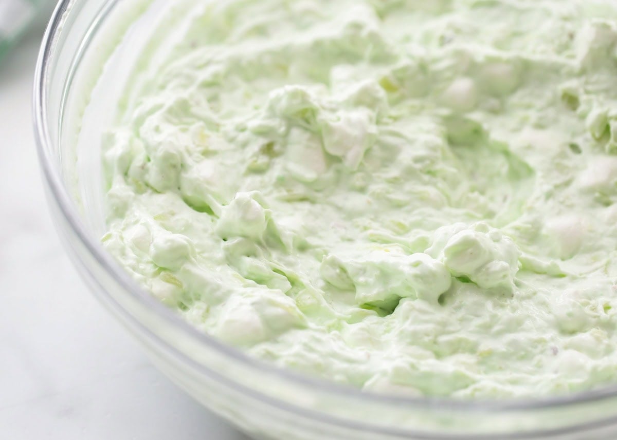 Pistachio salad ingredients mixed together in a glass bowl.