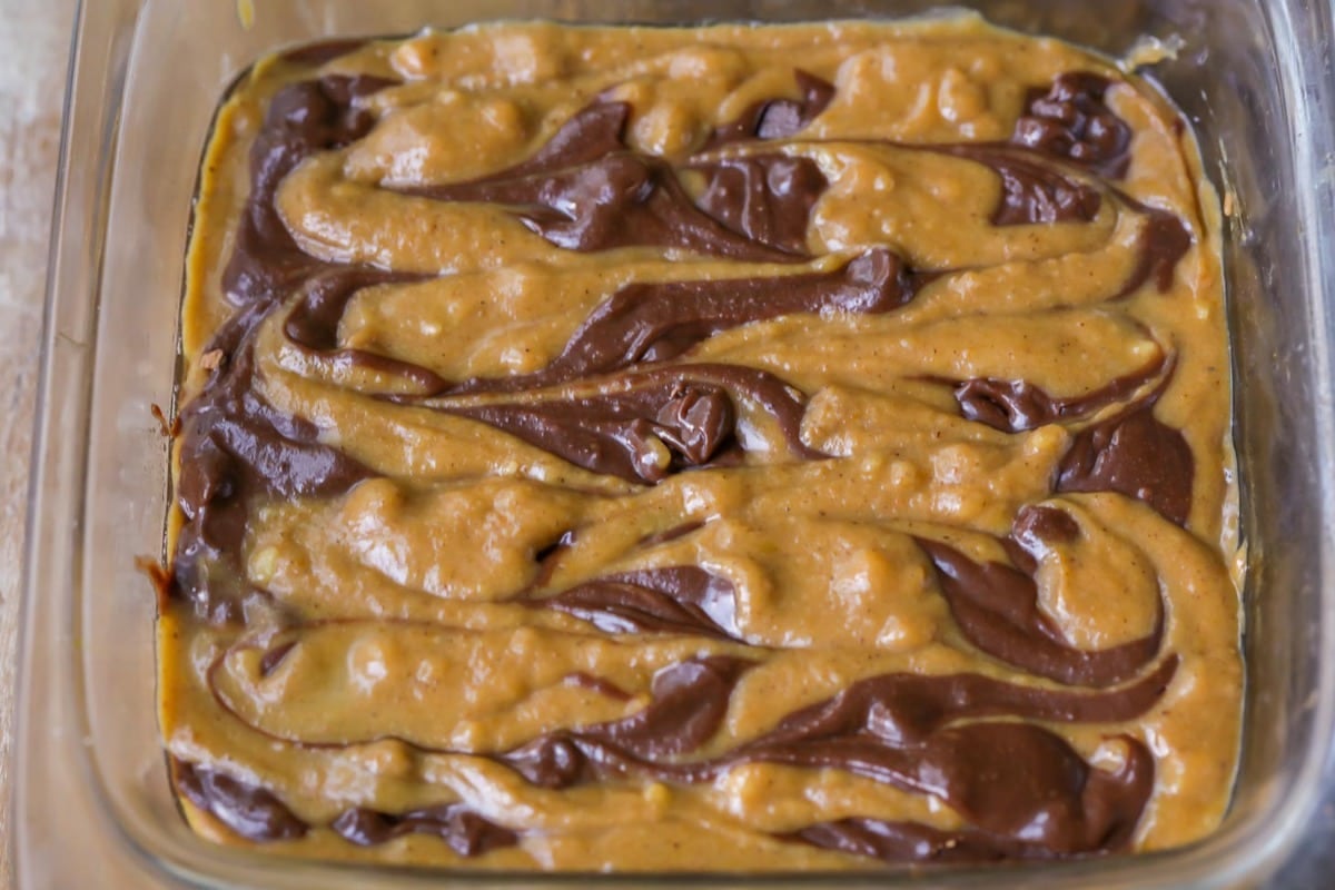 Pumpkin and chocolate batter swirled in a glass pan.