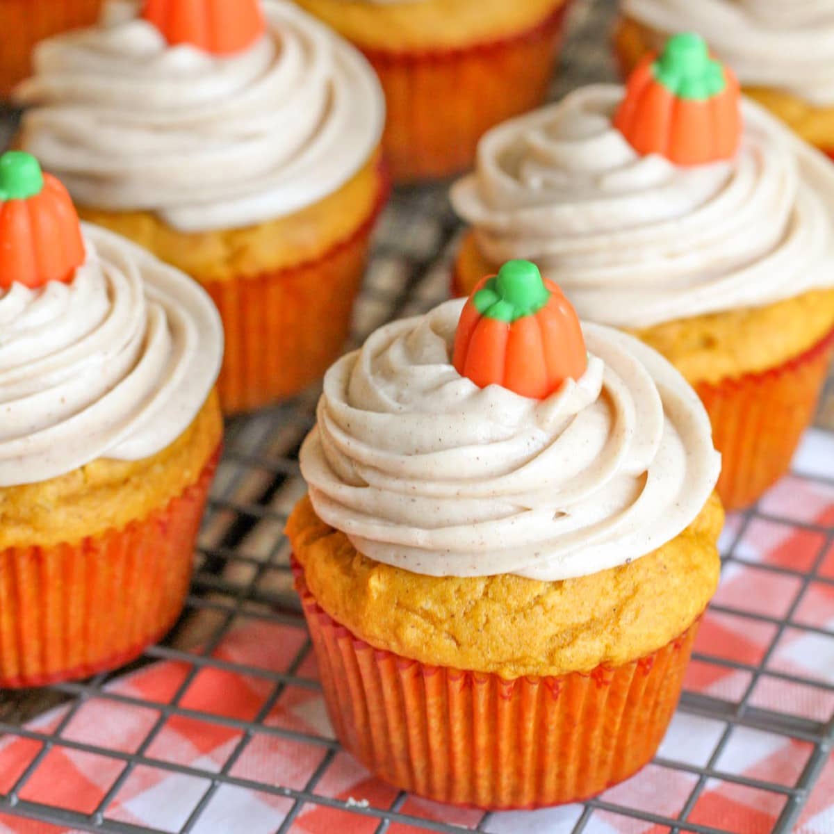 Thanksgiving desserts - several pumpkin cupcakes topped with frosting an pumpkin candy.