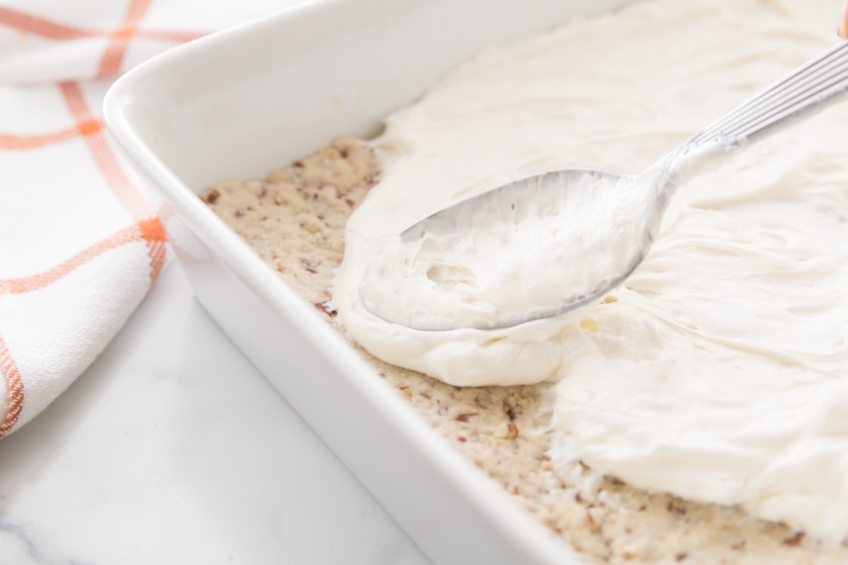 cream cheese layer spread on a pecan crust