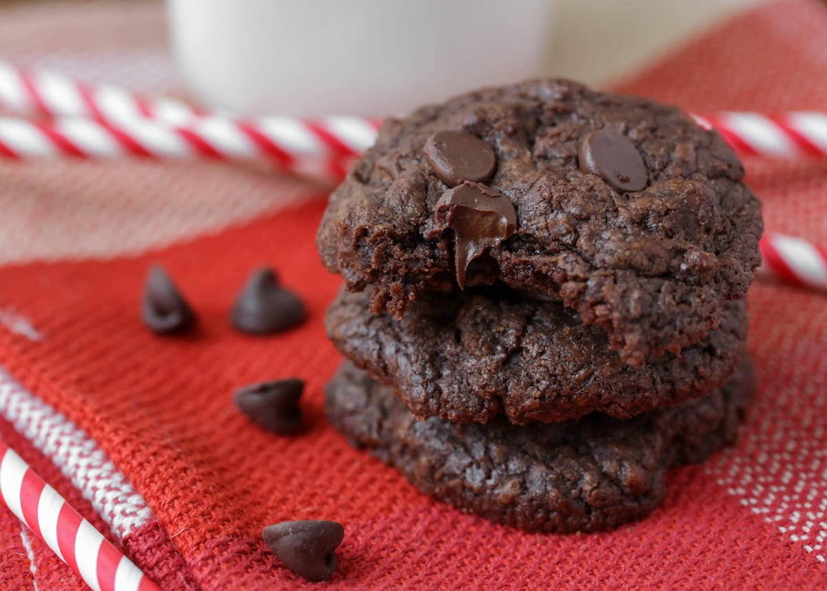 Chocolate brownie cookies stacked on a red cloth.