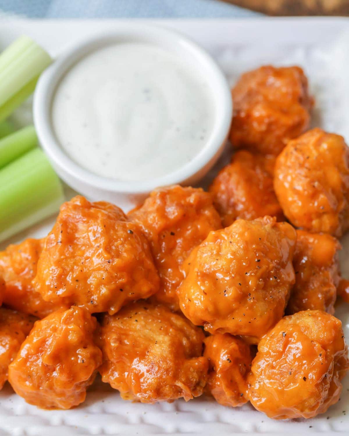 Boneless Buffalo Wings Recipe served with dressing and celery sticks.