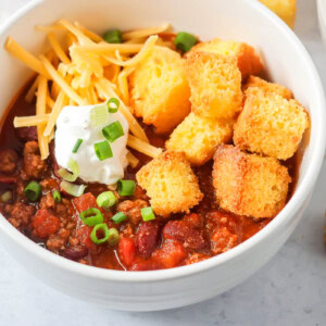 Chili recipe close up image with toppings on top of the chili.