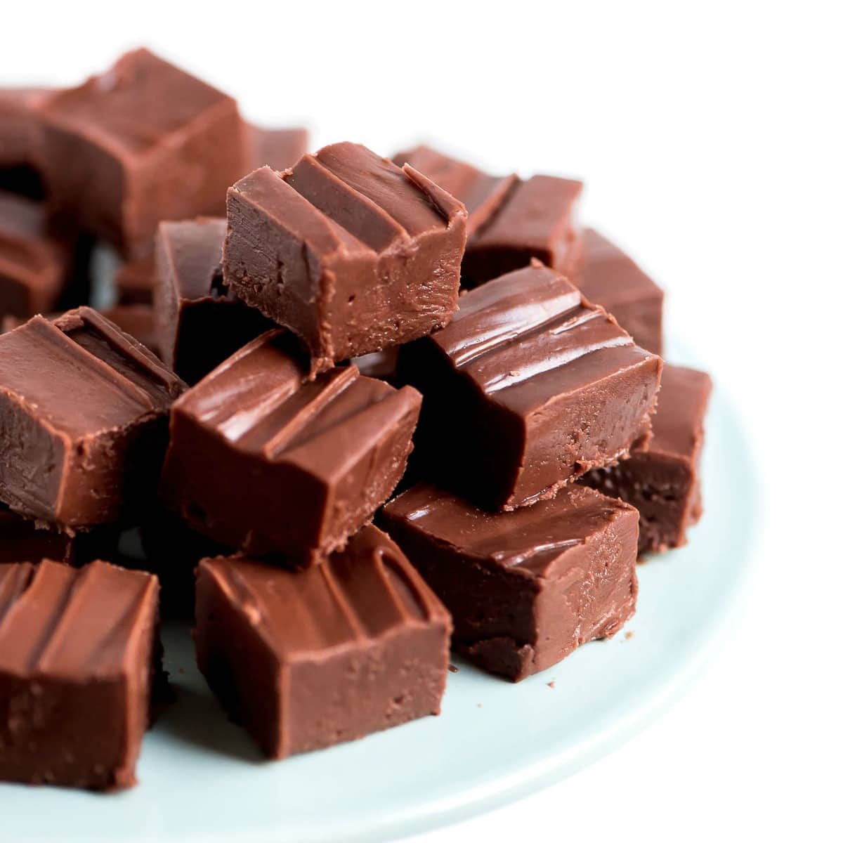 Chocolate Fudge recipe stacked on a white plate.