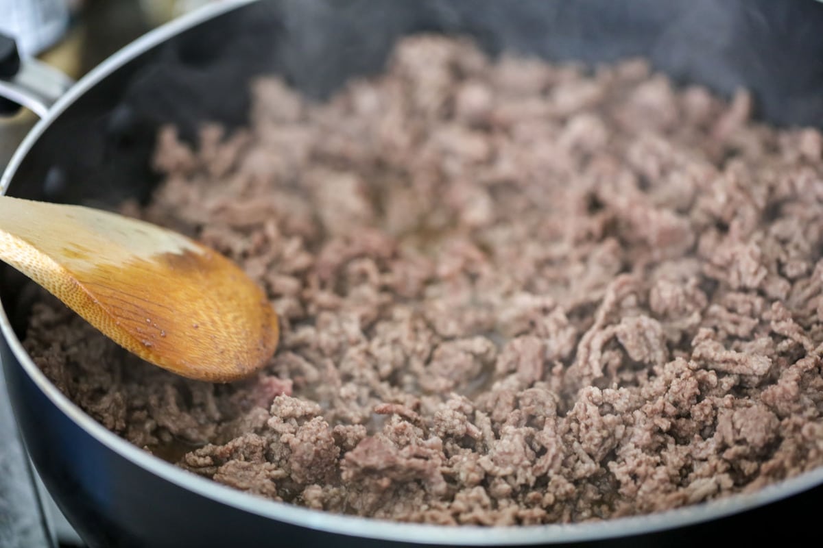 Cooking ground beef in a skillet for the best chili recipe.