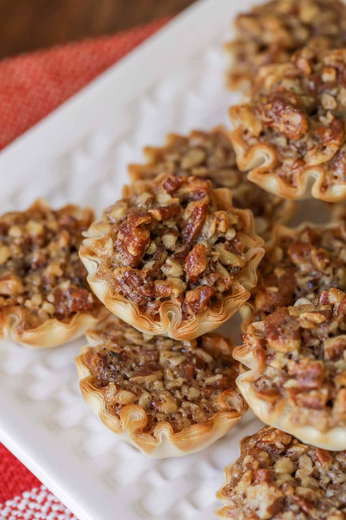 A close up of Mini Pecan Pie Recipe stacked on a white plate.
