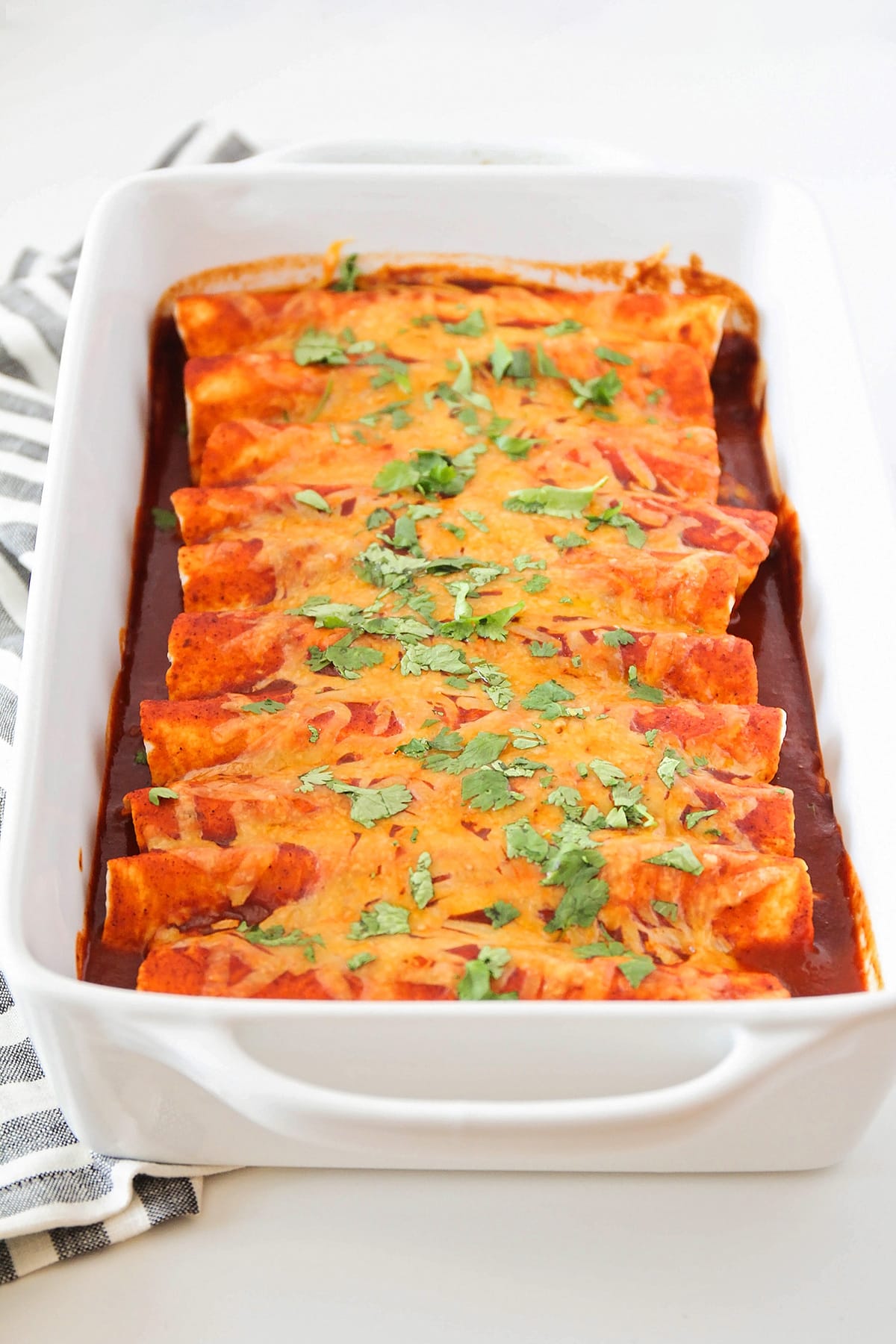 Easy shredded Beef Enchiladas in a casserole dish topped with cheese.