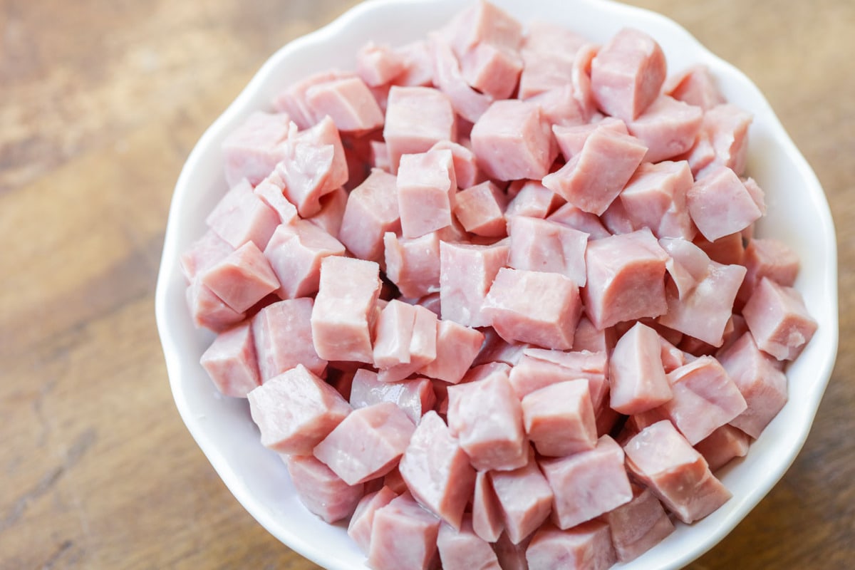 Pieces of cubed ham in a white bowl.