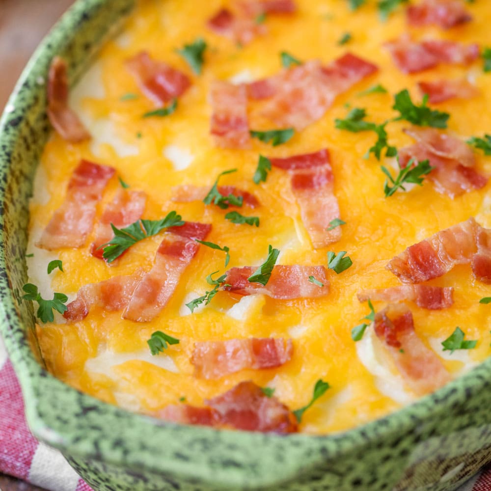 Close up of baked mashed potatoes topped with cheese and bacon.