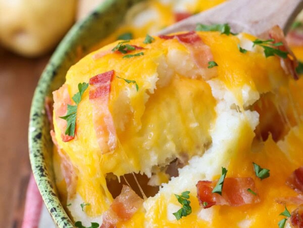 Baked mashed potatoes in a green serving dish.