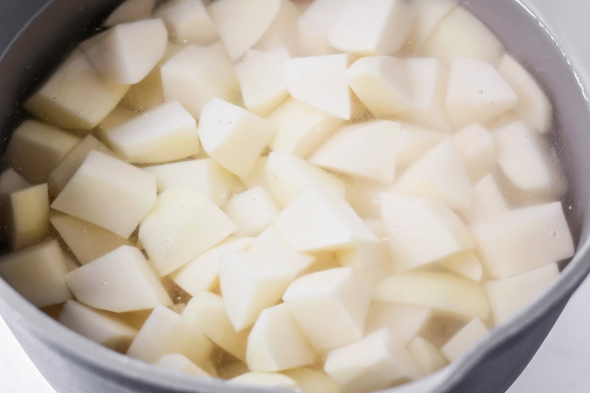 Potatoes in water about to be boiled in pot.
