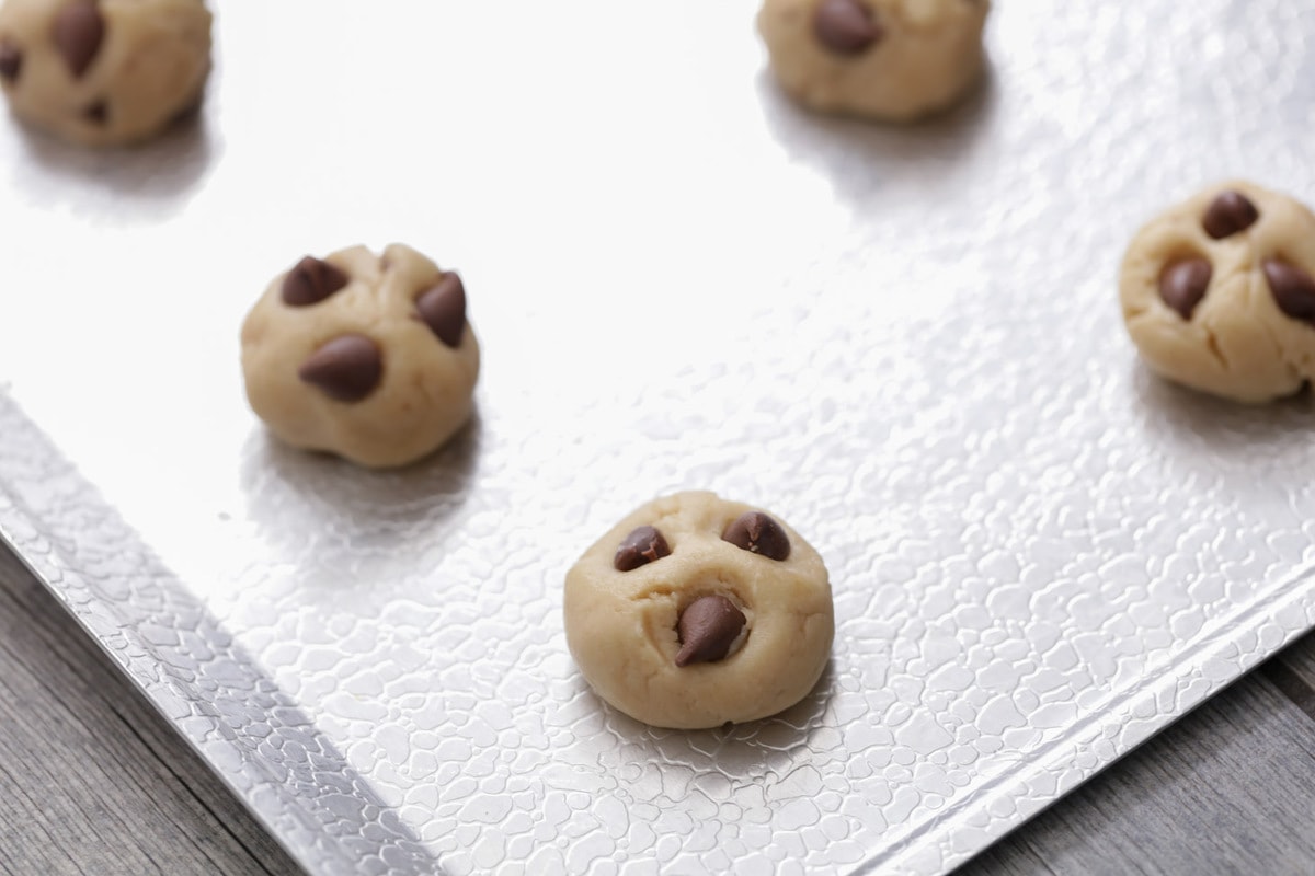 Mini cookie dough balls on a sheet pan.