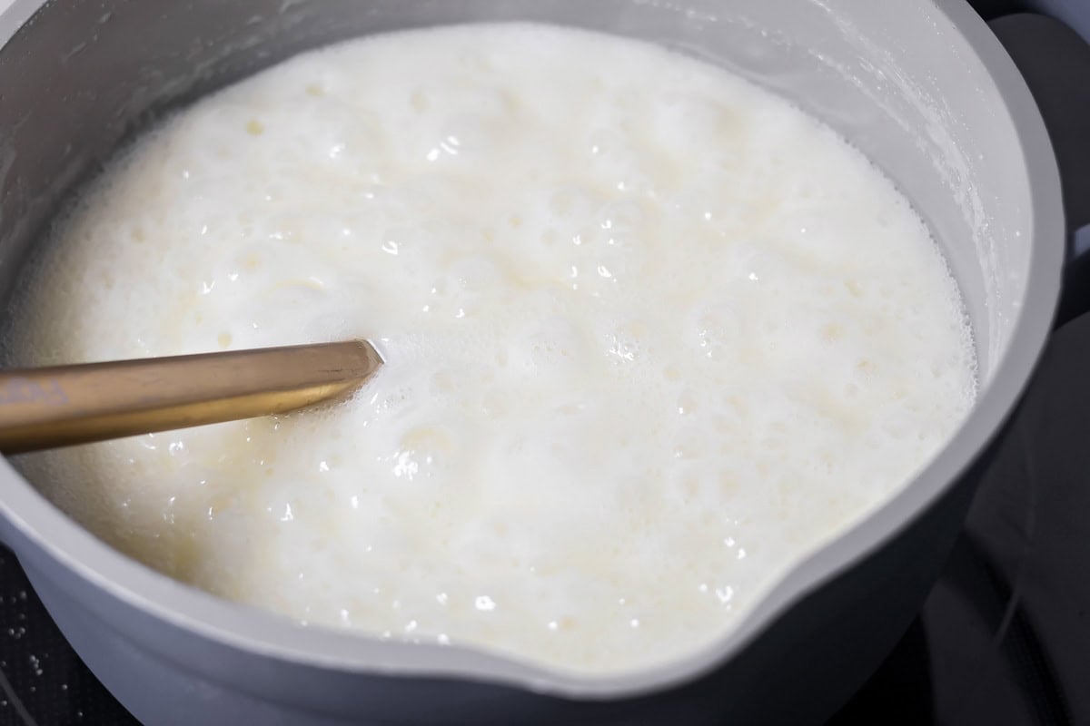 Sugar, butter and milk boiling in pot.