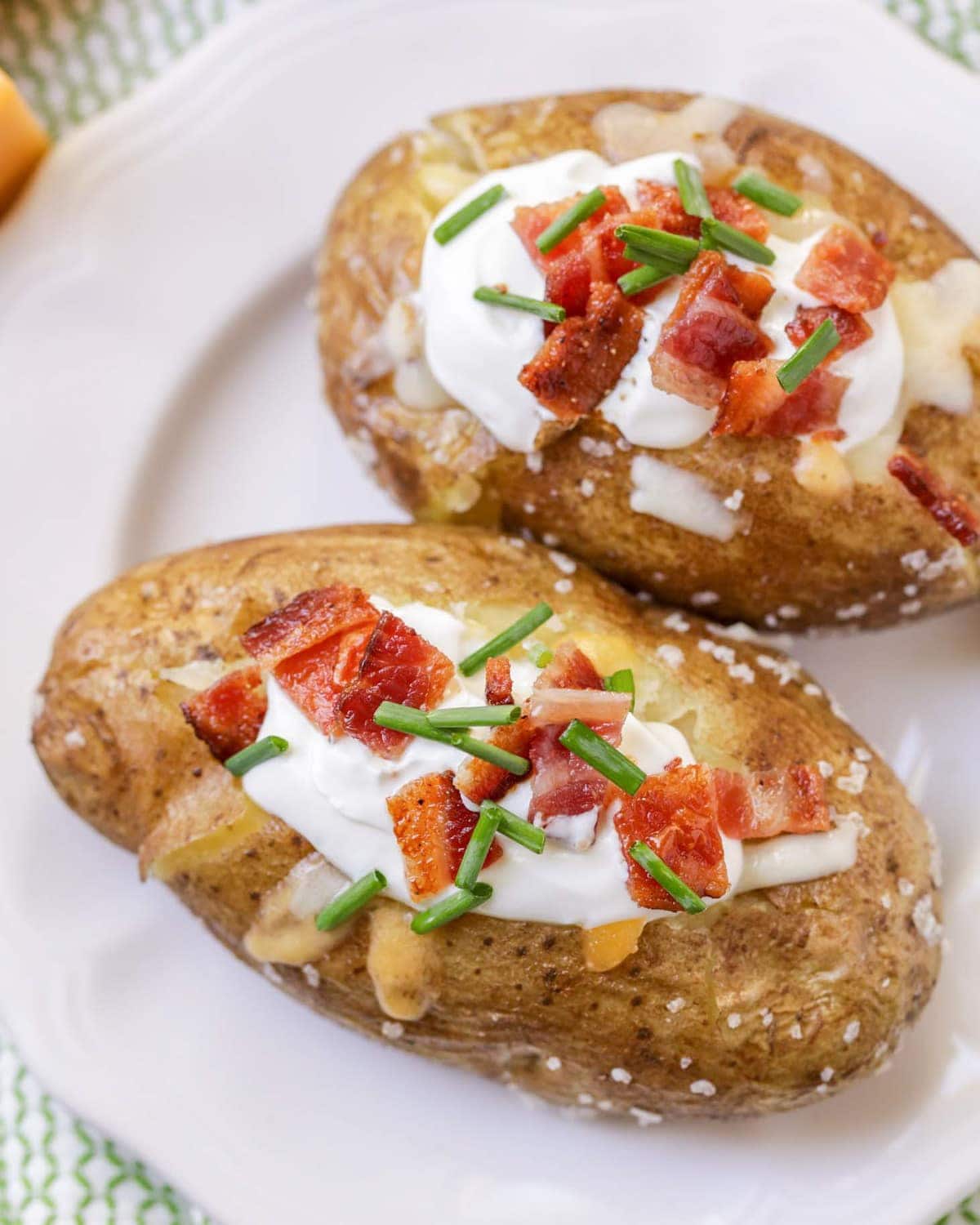 A perfect baked potato topped with sour cream and bacon.