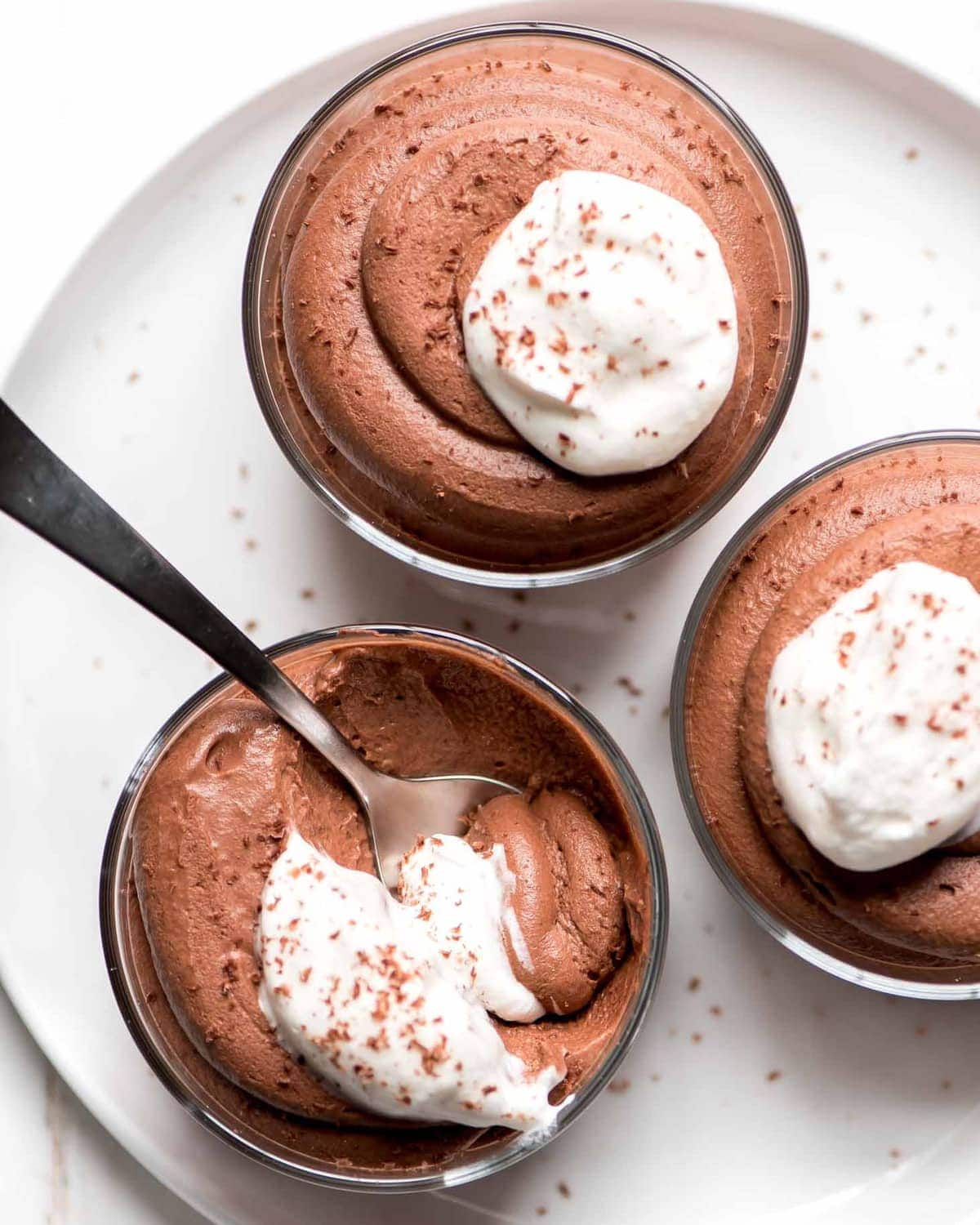 Easy Chocolate Mousse topped with whipped cream and sprinkled with chocolate shavings.