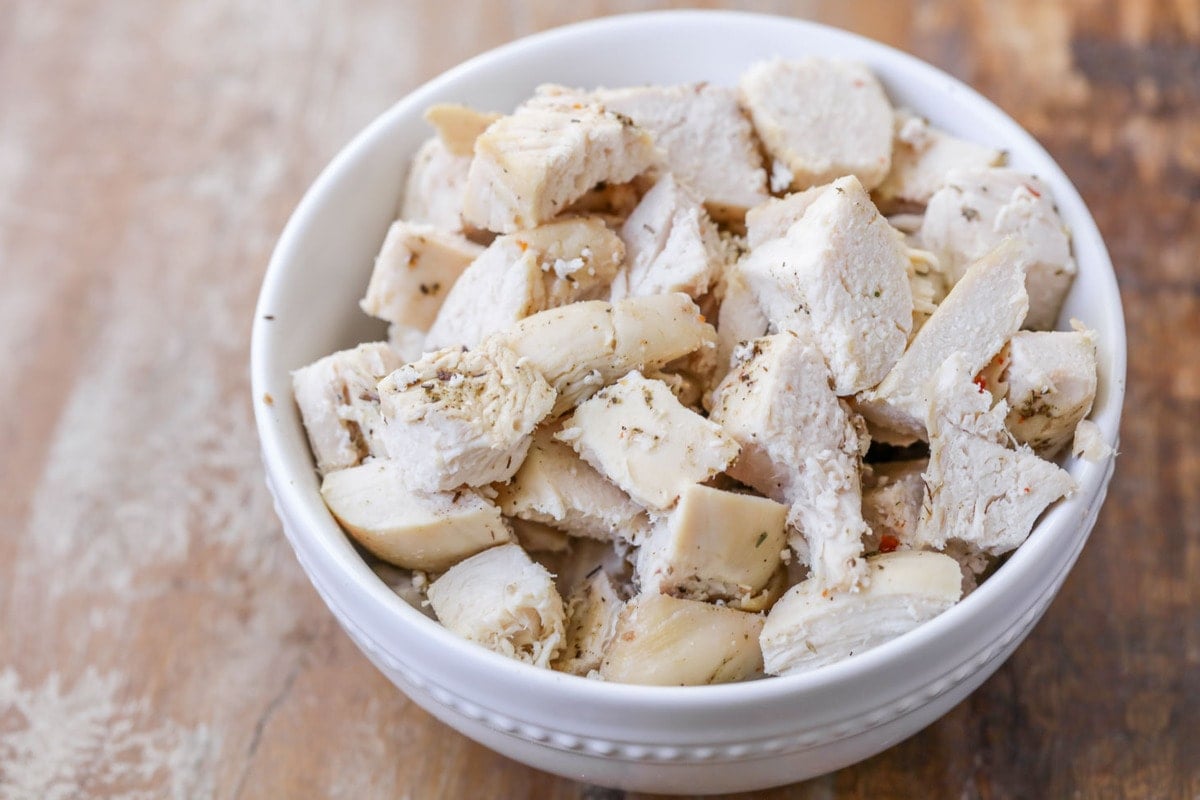 Cubed chicken for tetrazzini in a white bowl.