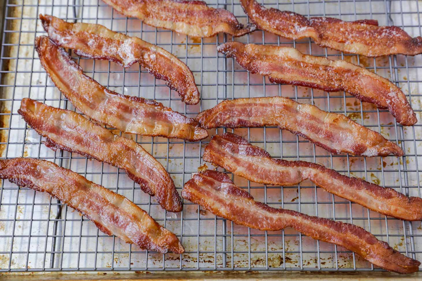 Bacon cooking on a wire rack.