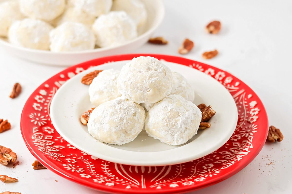 Snowball cookies on white and red holiday plate.