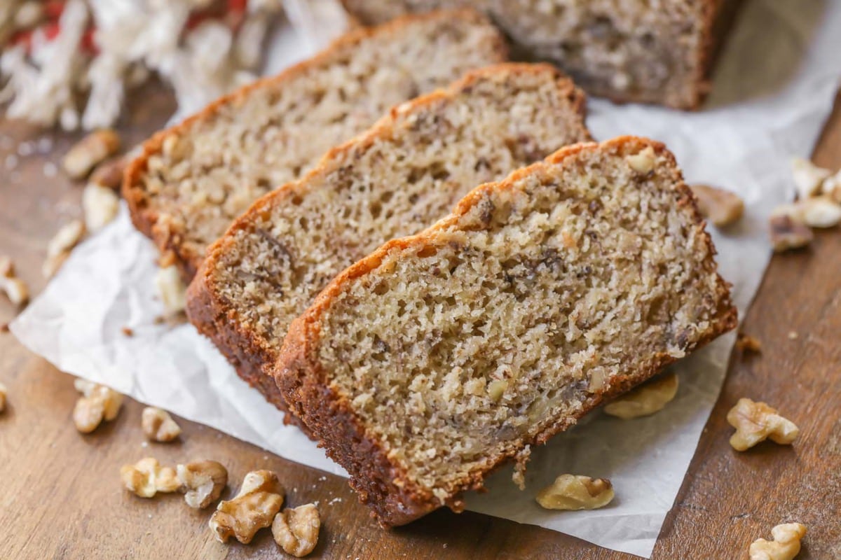 Banana nut bread sliced and served on a wooden table.