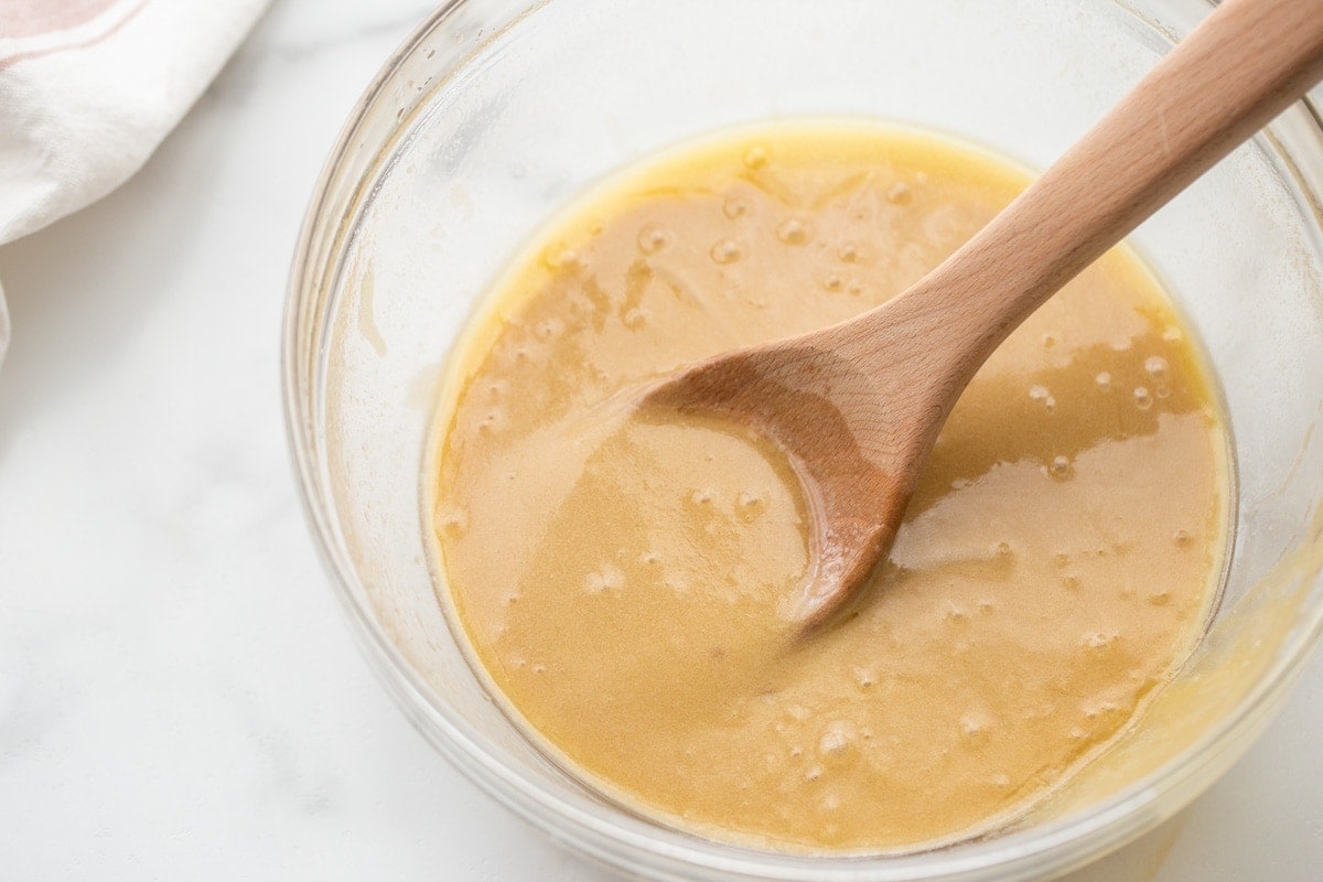 Stirring a caramel mixture in a glass bowl.