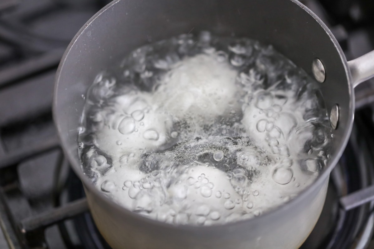 Eggs boiling in a pot of water.