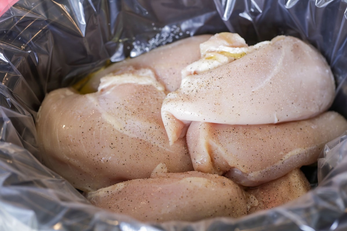 Crockpot Shredded Chicken with breasts in slow cooker.