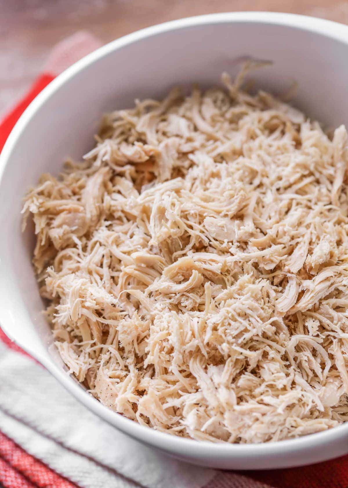 How to make shredded chicken in white bowl close up image.