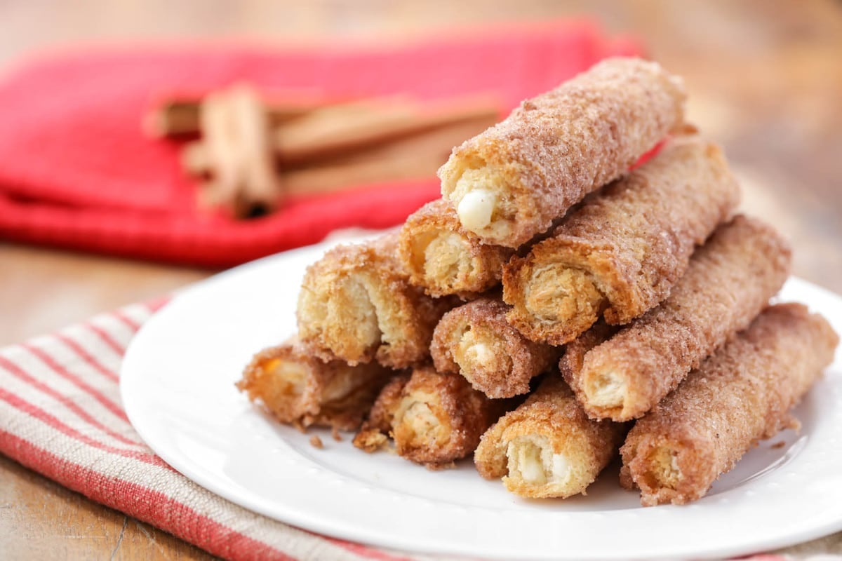 Easy Breakfast Ideas - a stack of cinnamon cream cheese roll ups on a white plate. 