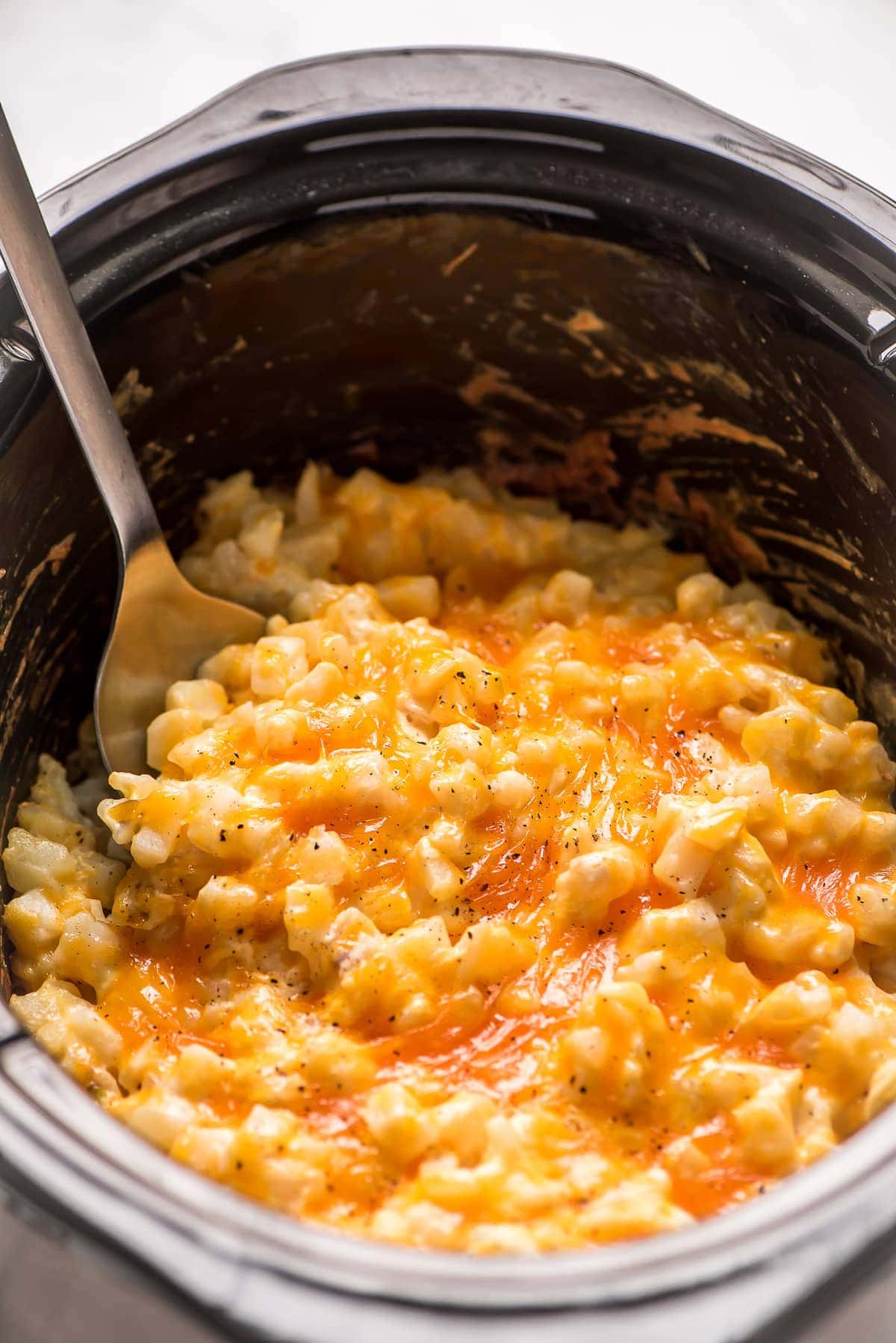Crockpot cheesy potatoes recipe covered in gooey cheese.