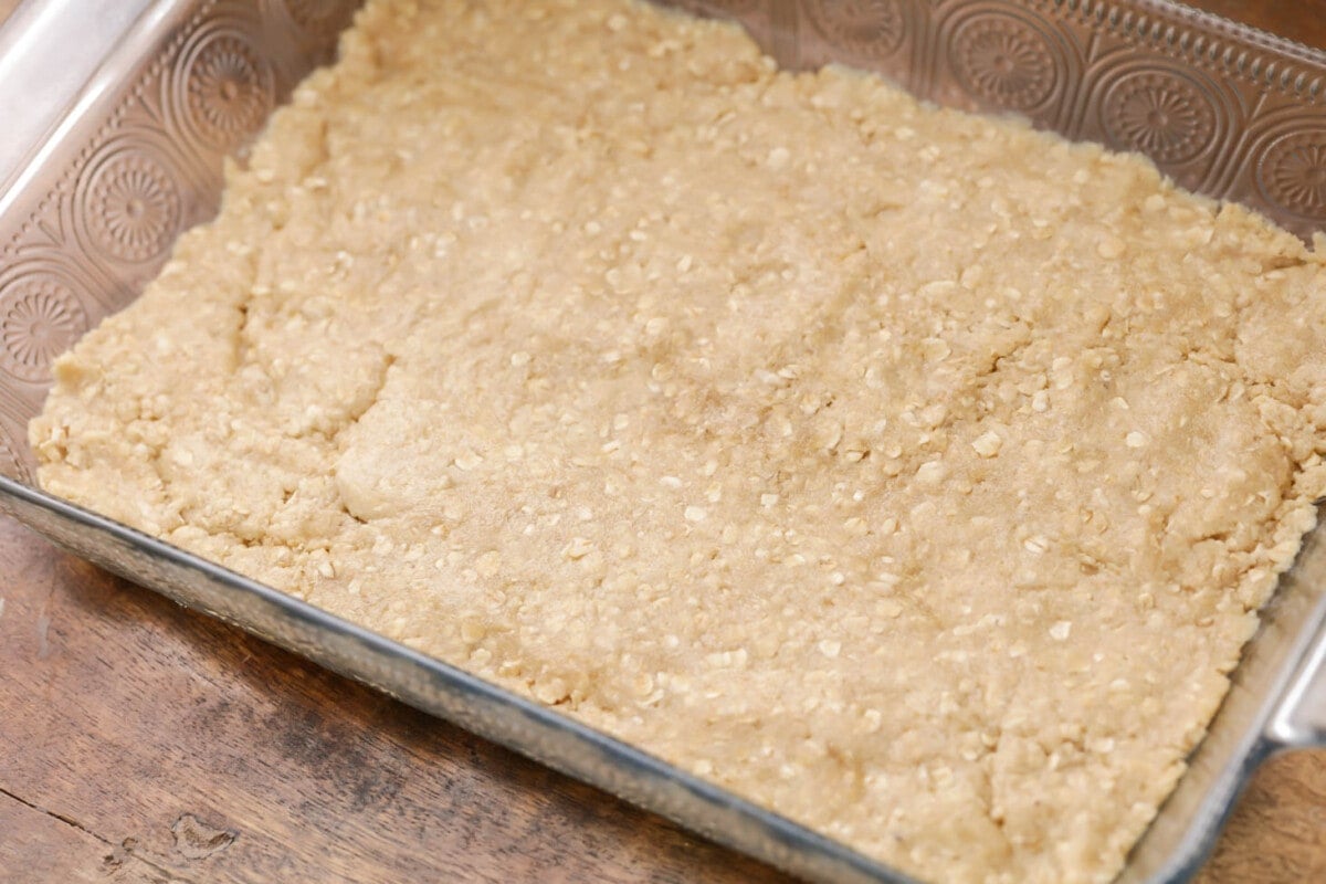 Oat mixture pressed into the bottom of a greased pan.