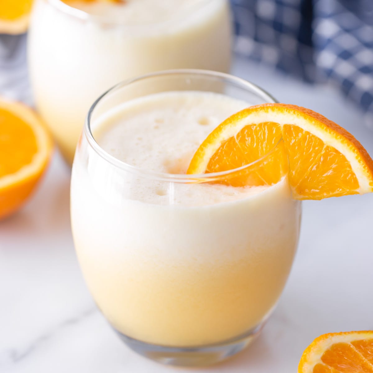 Orange julius served in a glass with fresh orange slice.