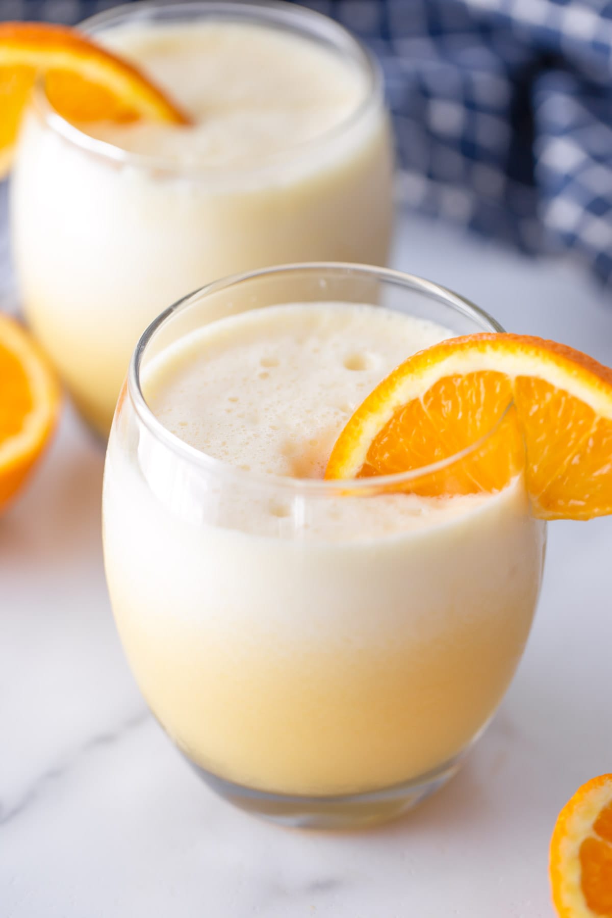 Close up of Orange Julius recipe in a glass with a slice of fresh orange.