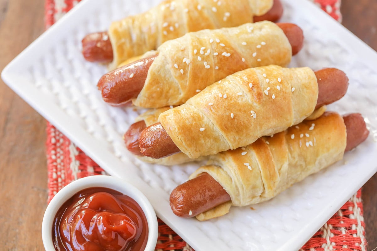 3 Ingredient Recipes - Four pigs in a blanket served on a white plate.