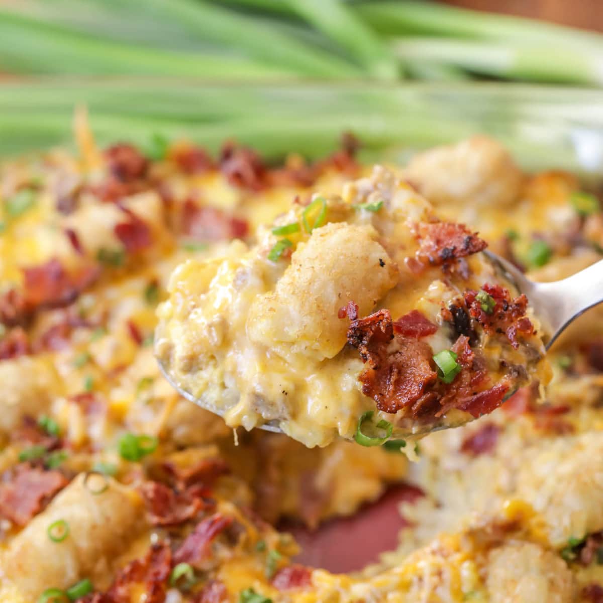 Breakfast for dinner - scoop of tater tot breakfast casserole topped with bacon.