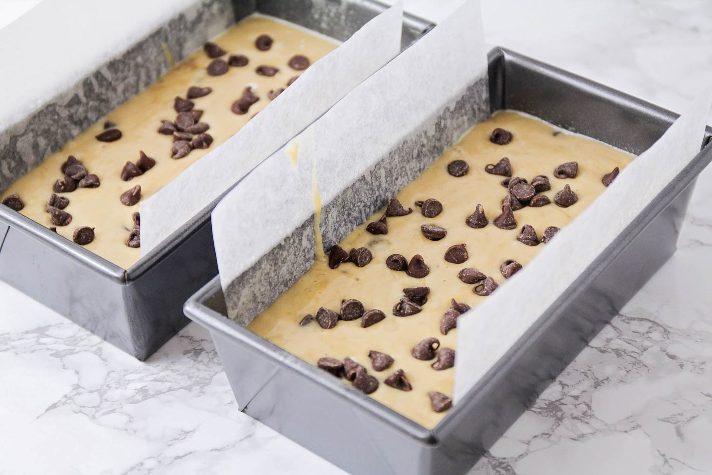 Chocolate chip banana bread batter in bread pans ready for baking.