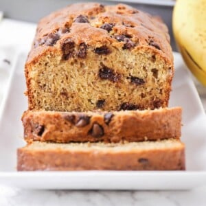 Chocolate chip banana bread recipe sliced on a white plate.