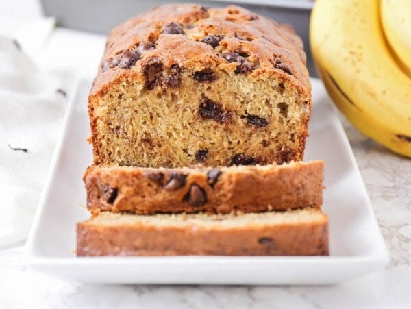 Chocolate chip banana bread recipe sliced on a white plate.