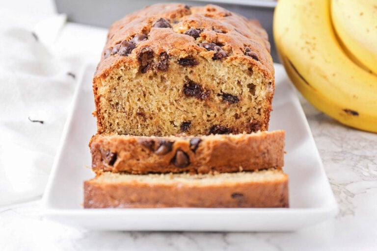Chocolate chip banana bread recipe sliced on a white plate.