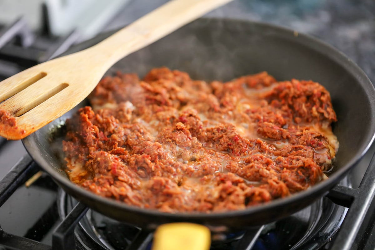 Cooking chorizo in a pan on the stove.