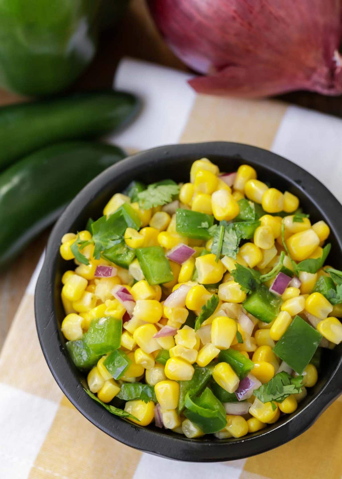 Fresh corn salsa served in a black bowl.