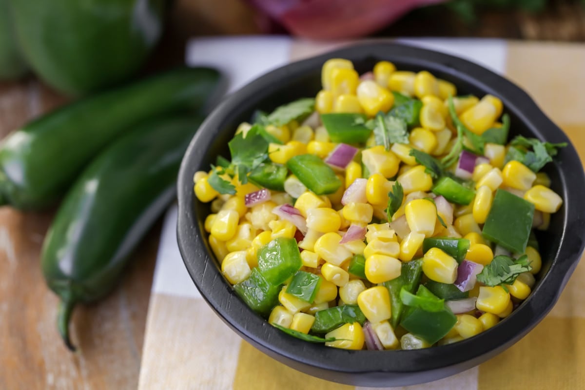 Corn salsa recipe served in a black bowl.