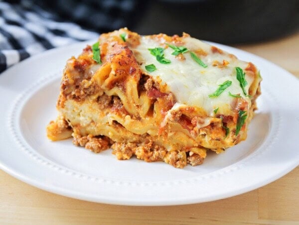 Crockpot lasagna sliced and served on a white plate.