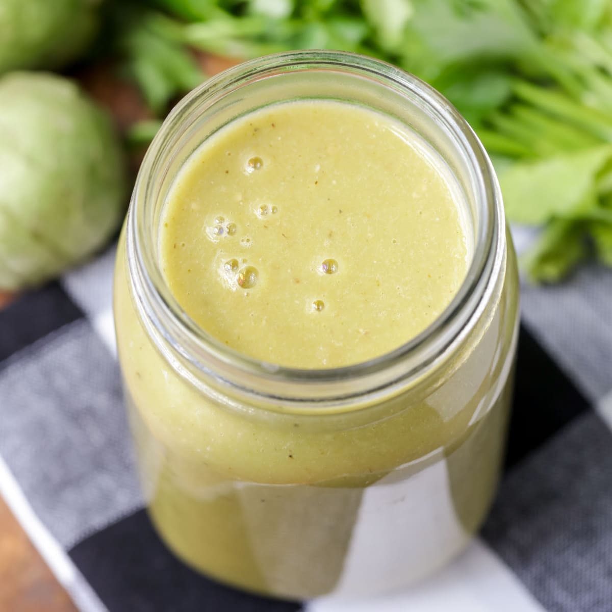 A mason jar filled with green enchilada sauce.