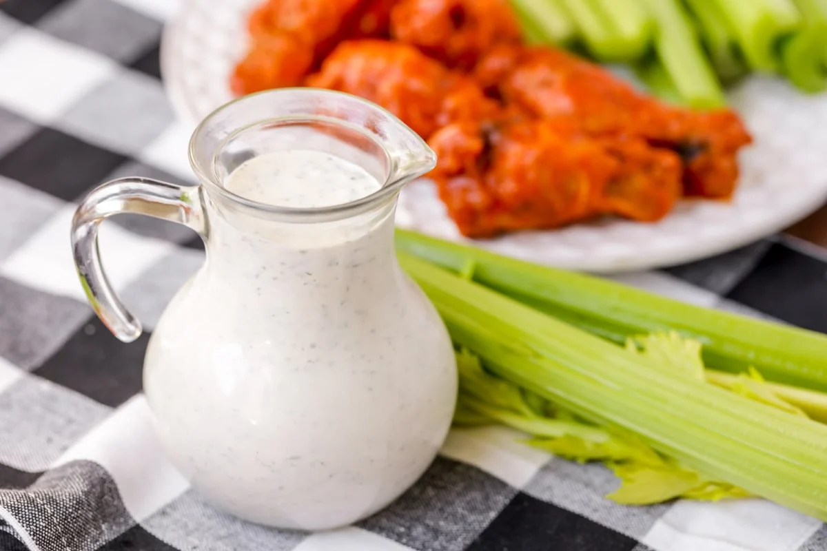 Ranch dressing served with buffalo chicken and celery.