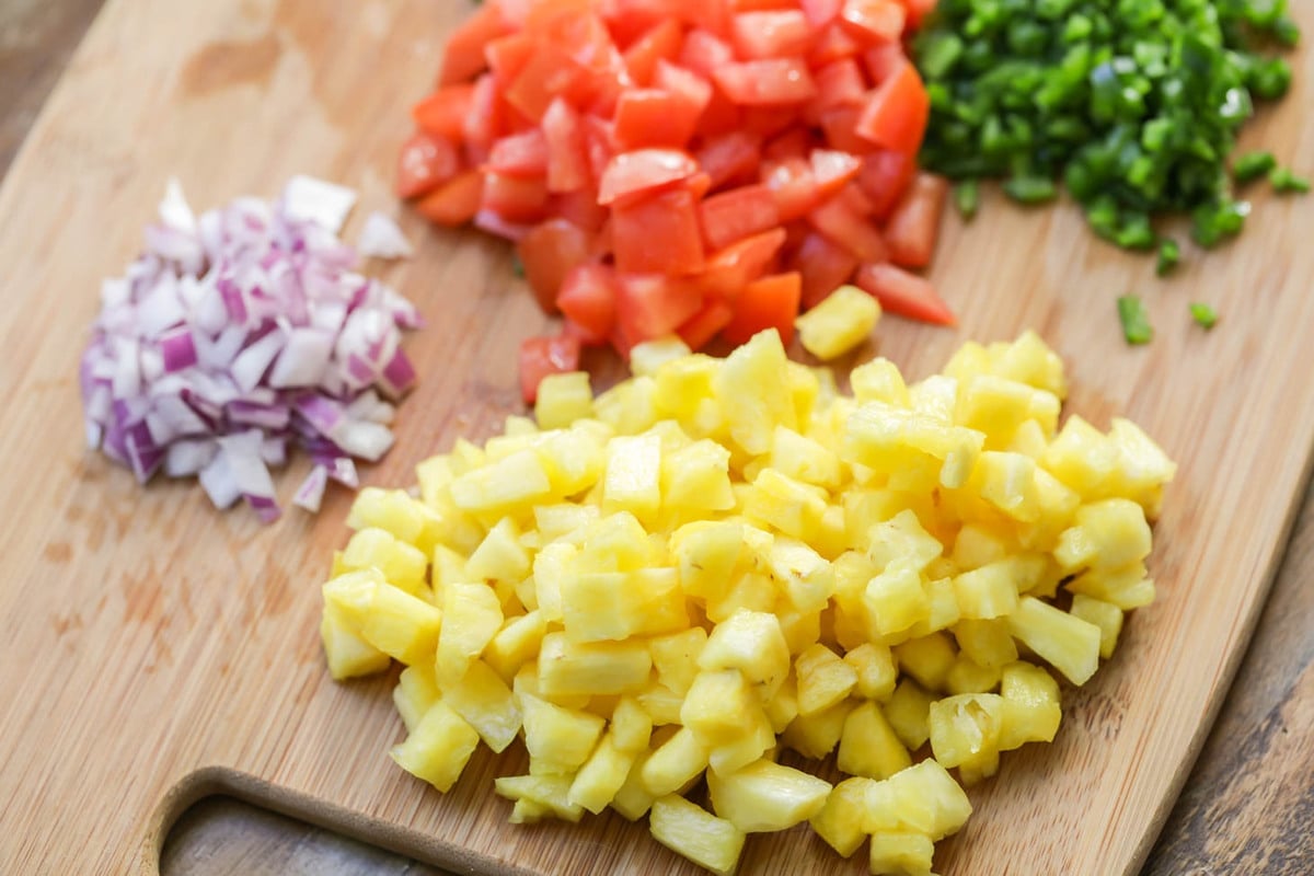 Pineapple salsa recipe ingredients on cutting board.