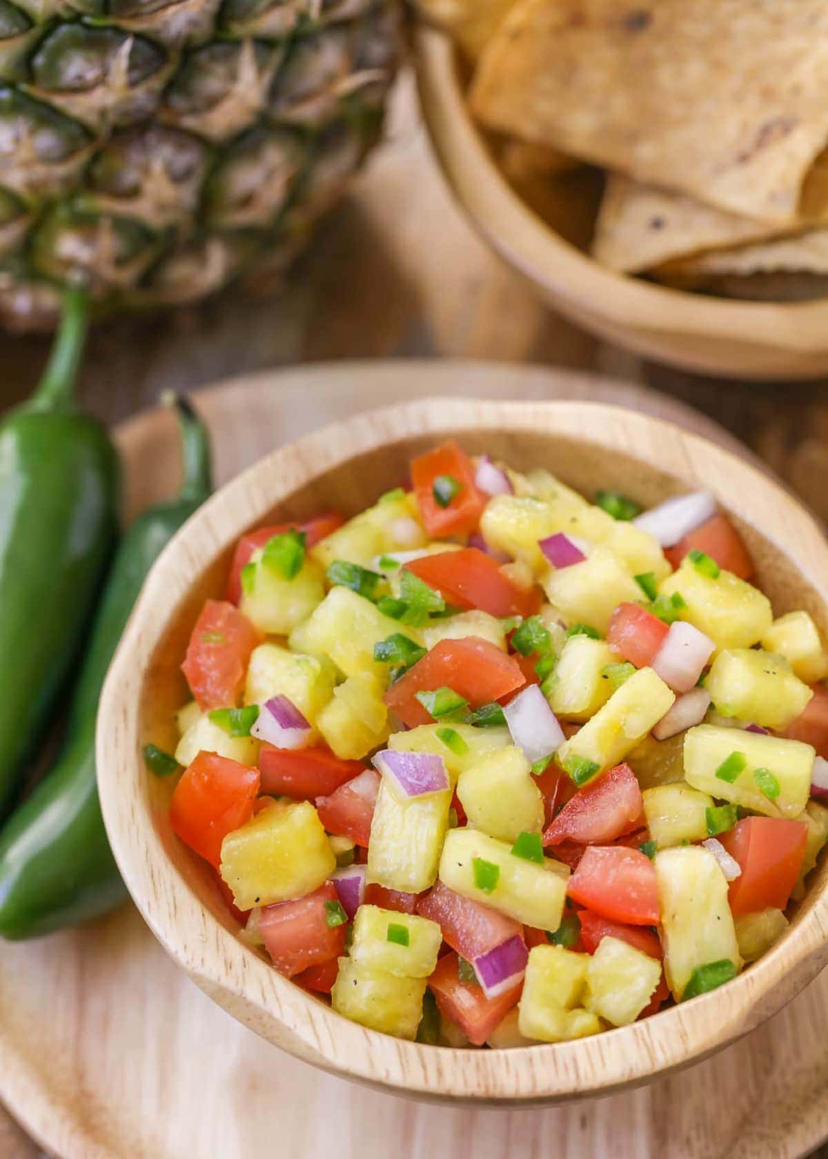 Pineapple jalapeno salsa served in a wooden bowl.